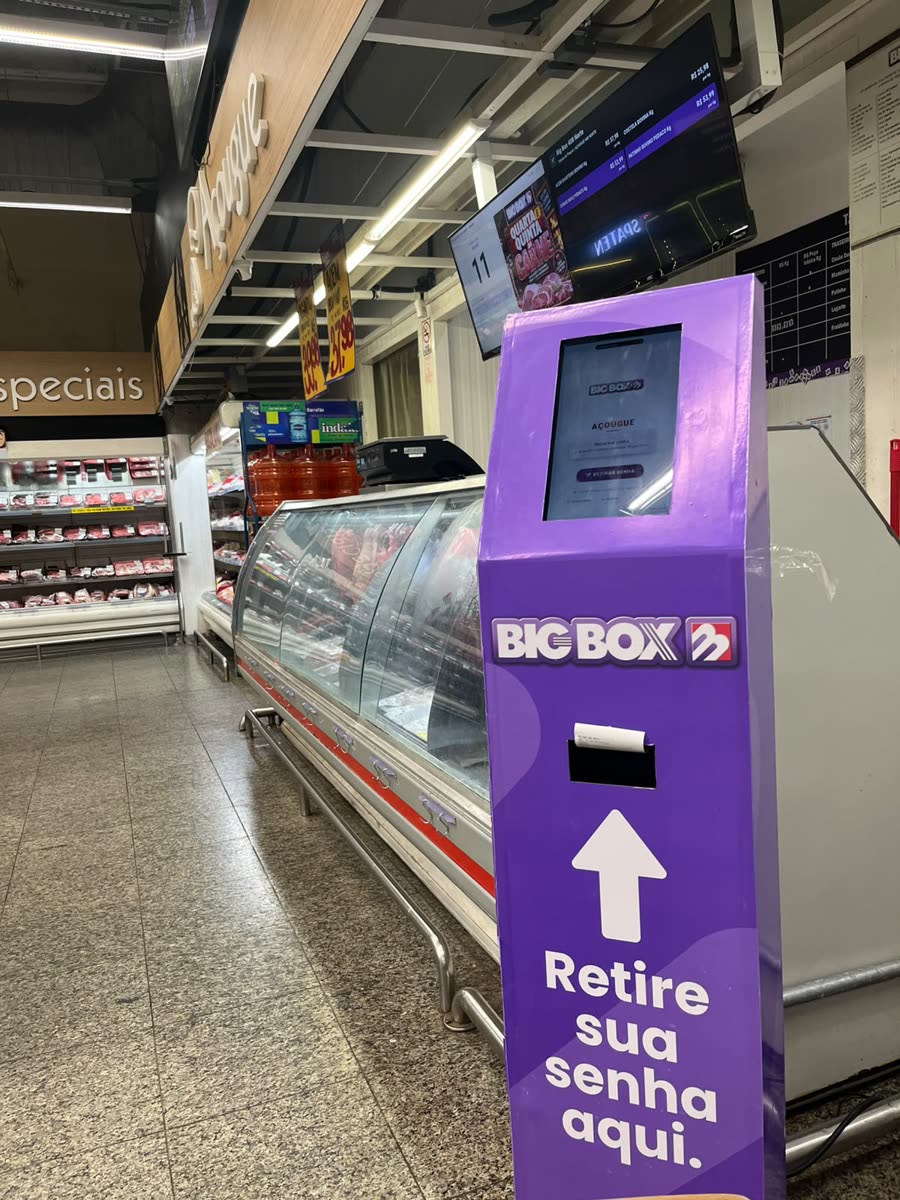 Totem de autoatendimento em MDF instalado no Big Box, com tablet e saída de impressora